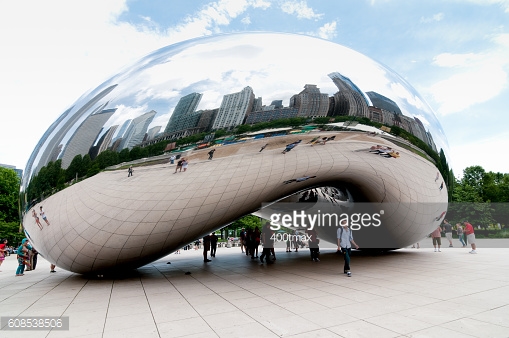 People gathered around the Bean early in the day in Millennium Park on a sunny day.