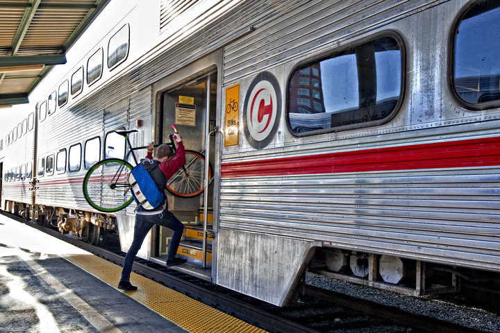 A commuter carries his bicycle aboard a Caltrain train in San Francisco, California, U.S., on Monday, Nov. 24, 2009. Caltrain and the California High-Speed Rail Authority have formed a partnership called the Peninsula Rail Program, which is jointly facilitating improvements to Caltrain under the Caltrain 2025 plan to bring high-speed rail to the Peninsula. Photographer: Chip Chipman/Bloomberg via Getty Images